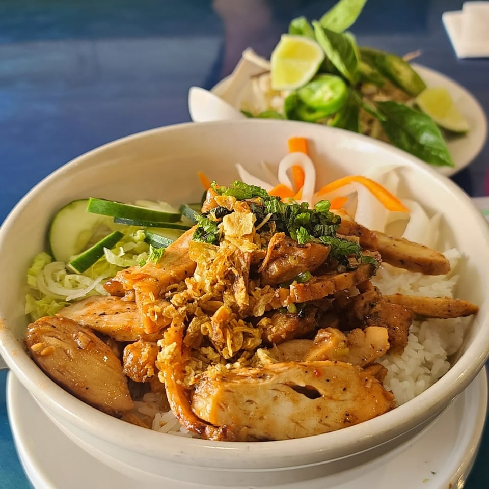Cafe LaVie's grilled chicken rice bowl with fresh vegetables and a side of herbs and lime.